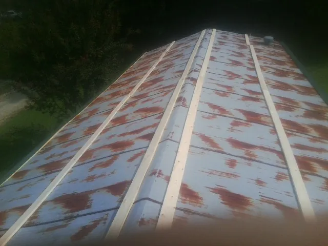 Rusted metal roof panels with new wood purlins before replacement — Storm Damage Roof Repair in Dameron by Roofing Brothers