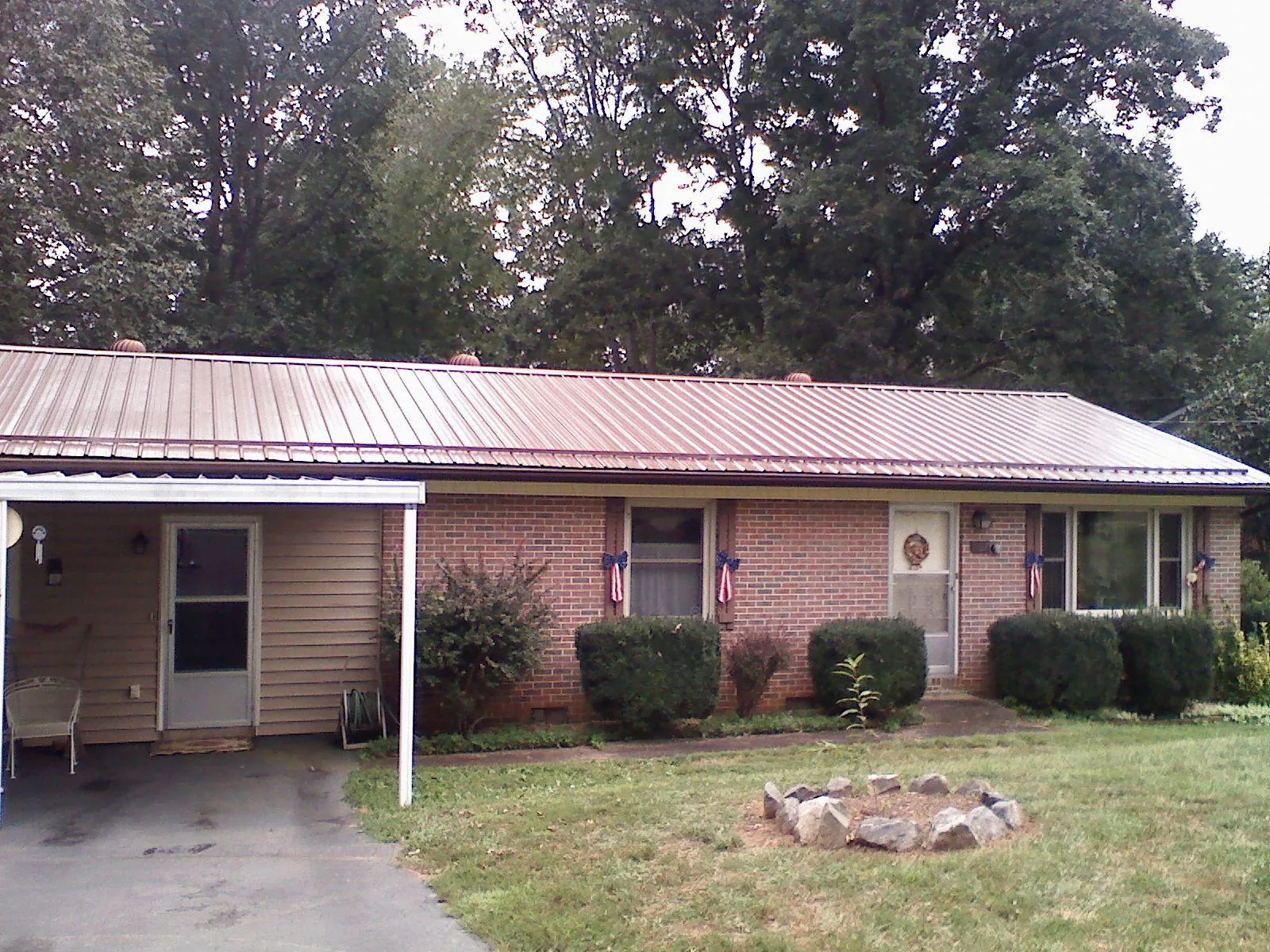 Bronze metal roof and carport on a brick ranch home — Roof Repair work by our crew in Dameron